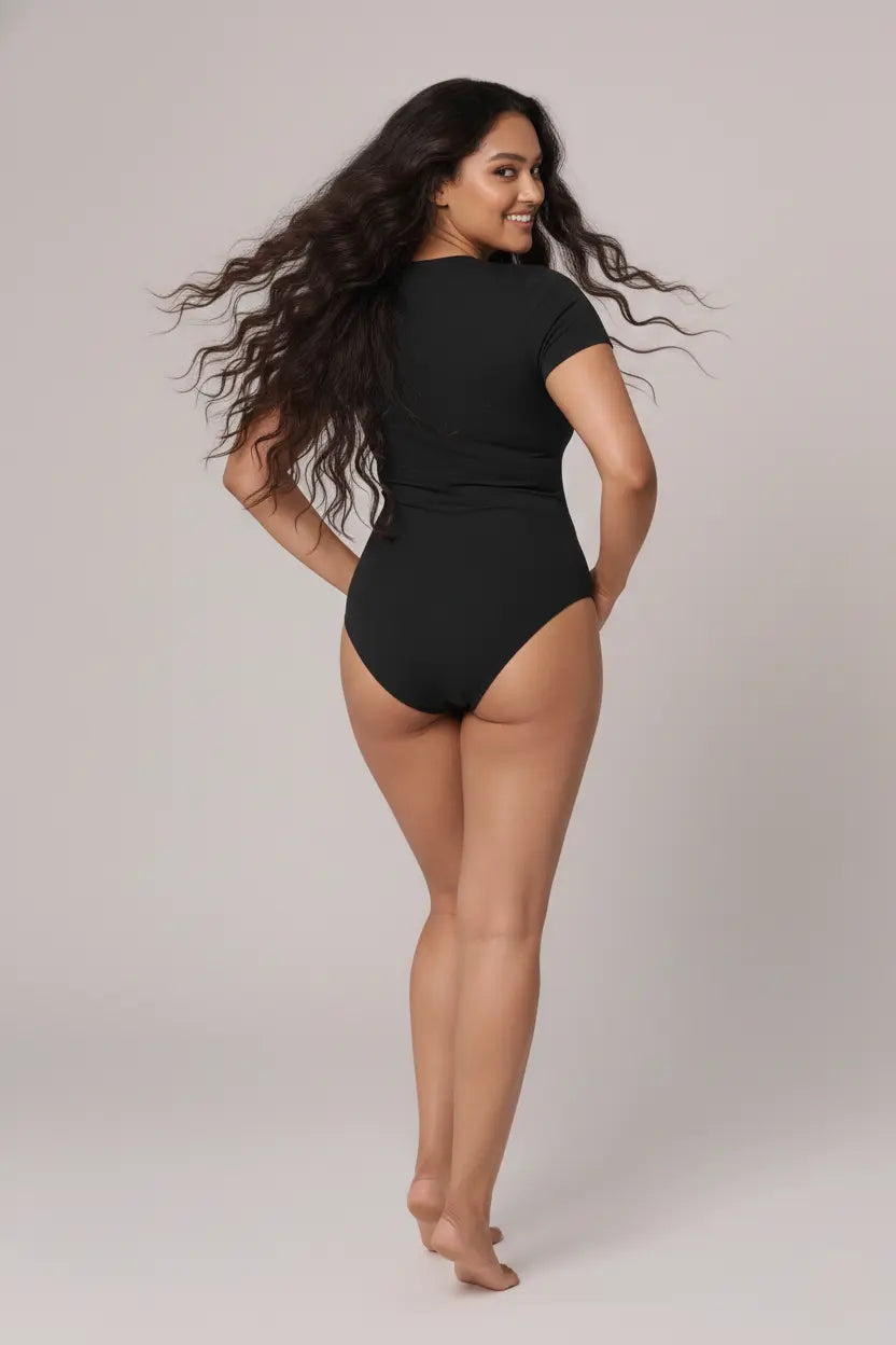 Woman wearing a black swimsuit against a plain background