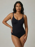 Woman wearing a black bodysuit against a neutral background