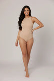 Woman wearing a beige swimsuit on a plain background
