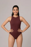 Woman wearing a maroon swimsuit against a plain background