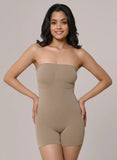 Woman wearing a beige strapless bodysuit against a plain background